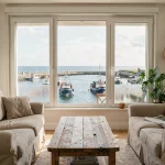 Salon d'un appartement à Concarneau avec vue mer panoramique sur le port, ambiance chaleureuse et authentique